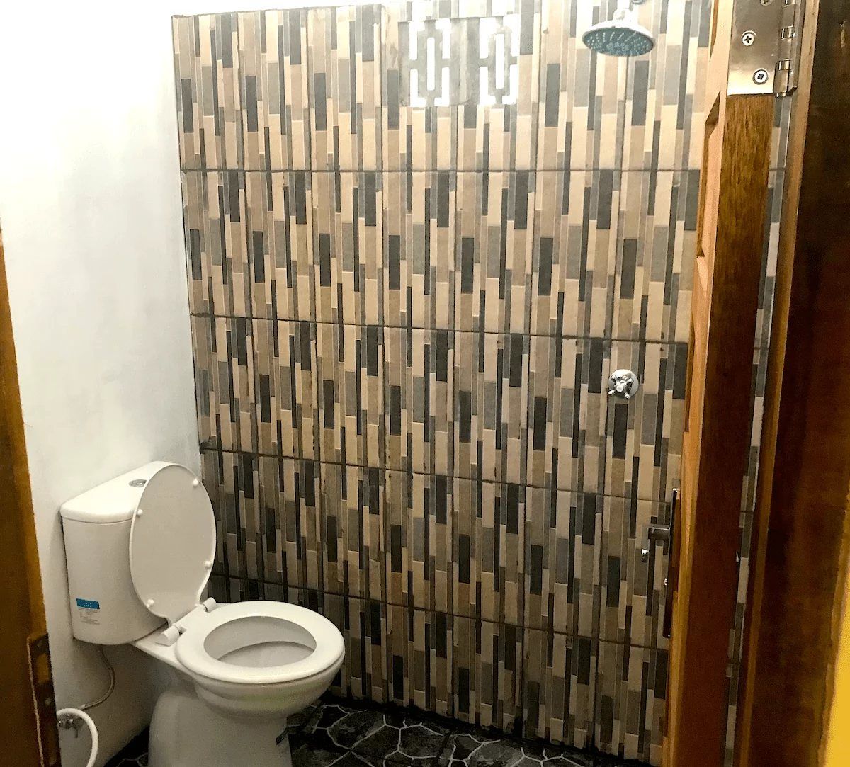 The private bathroom of a Classic Bungalow, with a tiled shower area and a toilet.