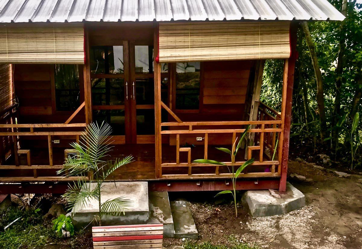 The front of a Classic Bungalow, with its wooden terrace and bamboo blinds.