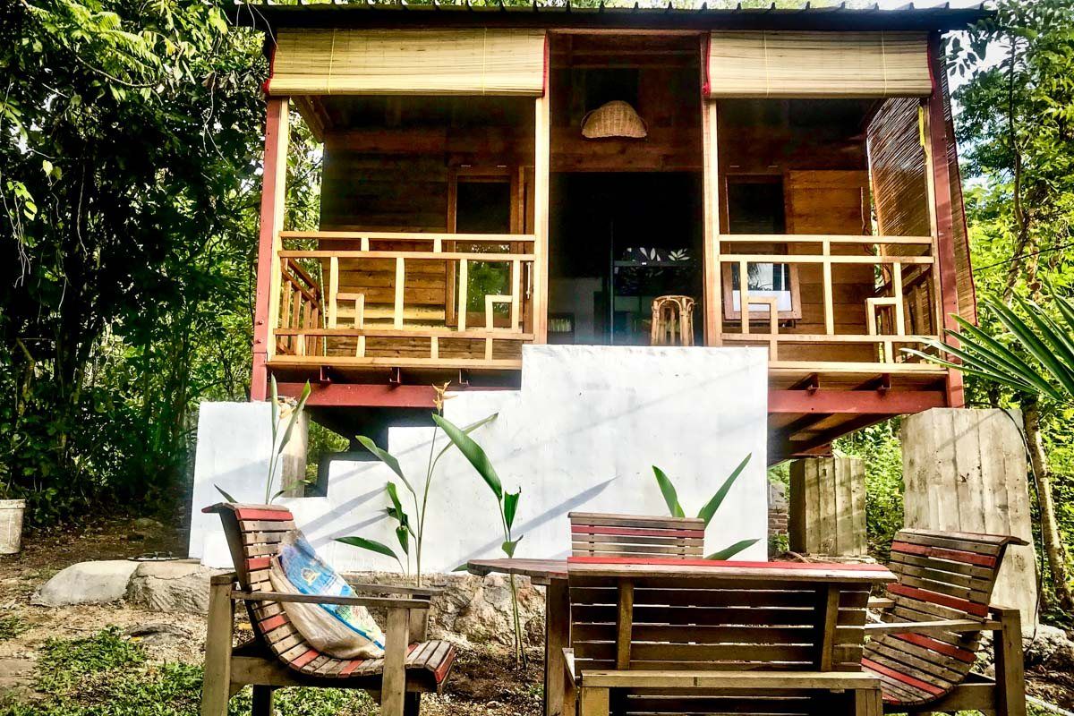 The dormitory building on stilts, with wooden chairs and a table on the terrace.