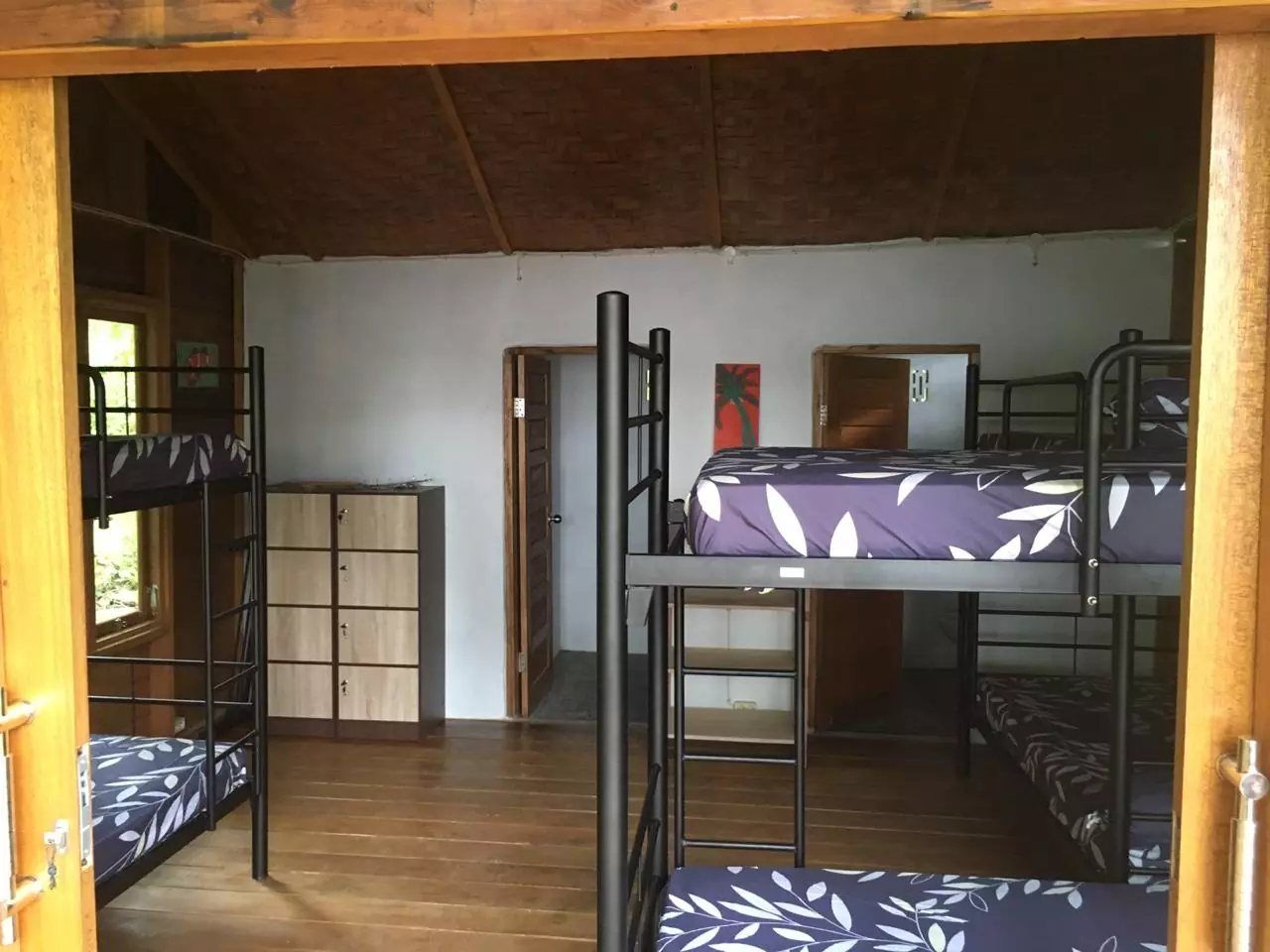 The dormitory seen from the doorway, with bunk beds along the walls and a bank of lockers.